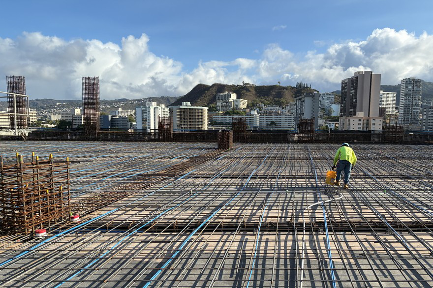 Construction worker preps section of the new parking lot's ninth floor Construction worker preps section of the new parking lot's ninth floor