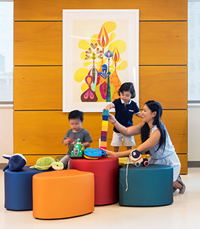 A mother and two children playing with colorful blocks
