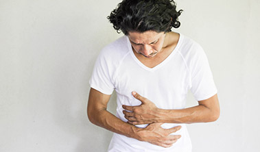 Man looking down and holding abdomen.