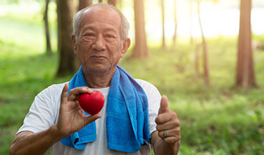 Fit elderly man holding heart shaped stress ball