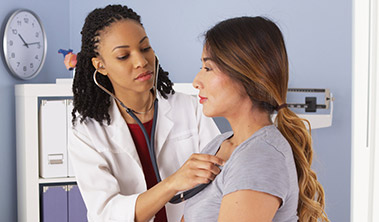 Doctor listening to the heart of her patient through a stethoscope