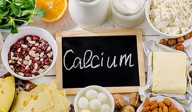 Healthy food surrounding chalk board that reads calcium.