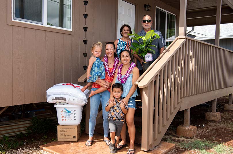 Multigenerational family on the steps of their new home.