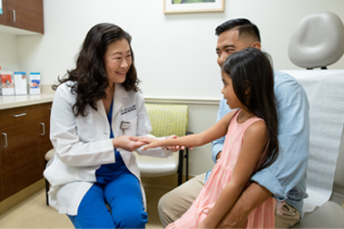 Doctor examines a young girl's wrist.