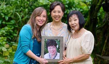 3 women holding a framed photo a loved one