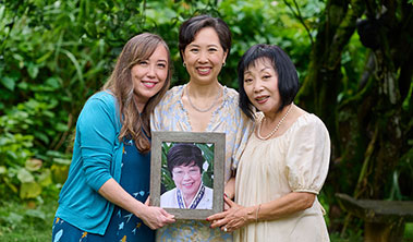 3 women holding a framed photo a loved one