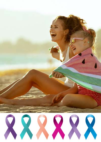 Woman and child sitting on beach smiling.