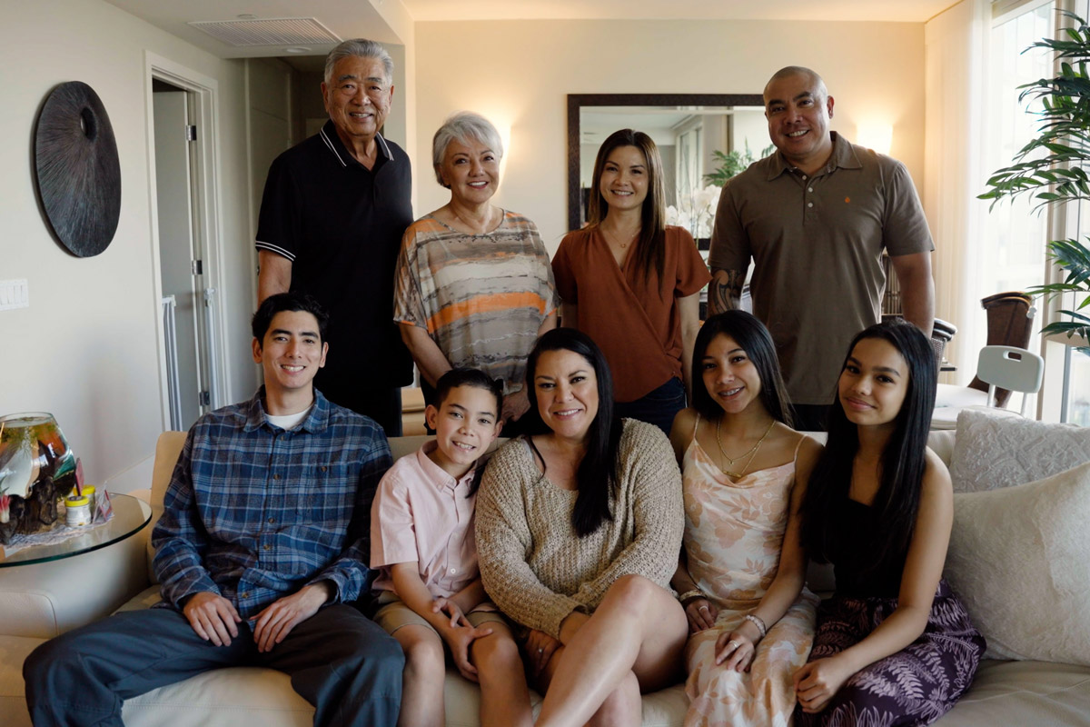 a family stands together in their living room