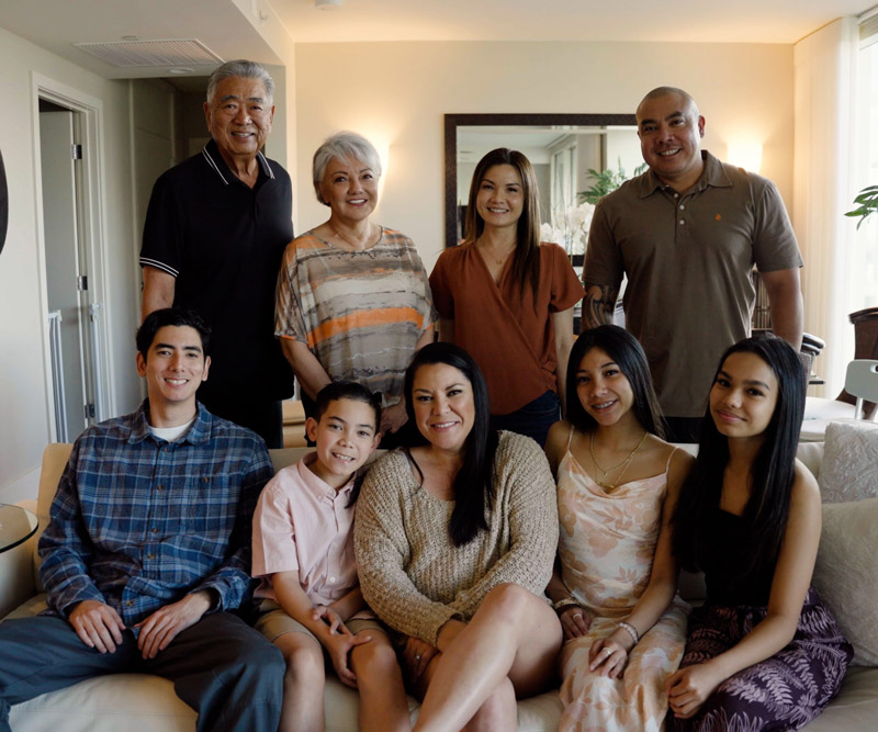 a family stands together in their living room