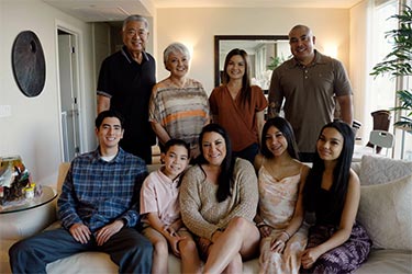 Group portrait with nine people in family living room.