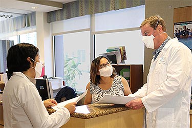 Doctor speaking with support team in medical office.