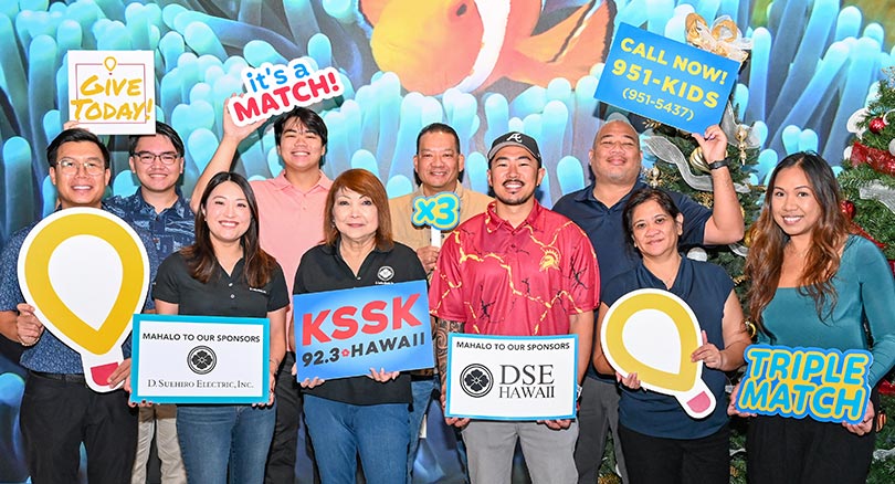 Group shot of people holding fundraising signs thanking sponsors and encouraging people to donate.