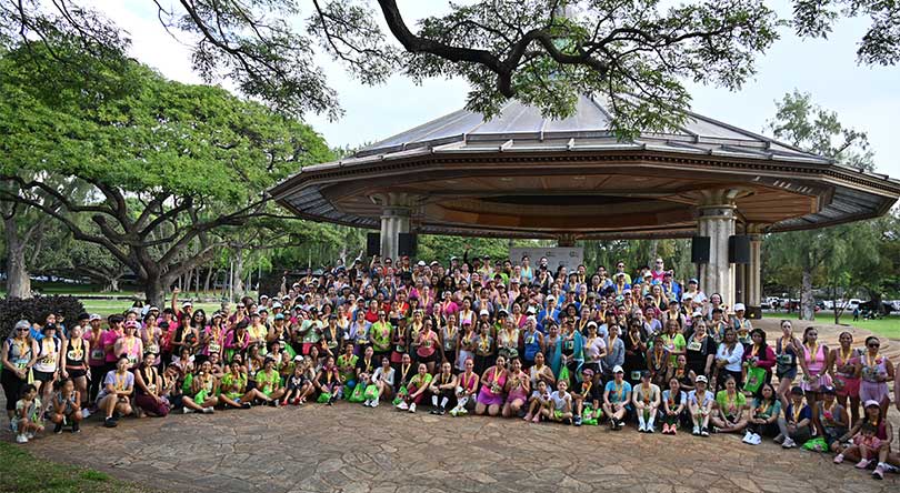 Large group of female race participants gathered at the Kapiolani Park Bandstand.