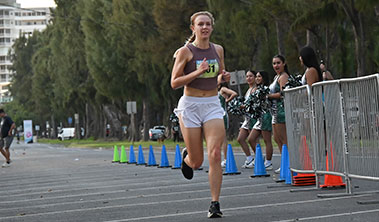 Woman running strong towards the finish line.