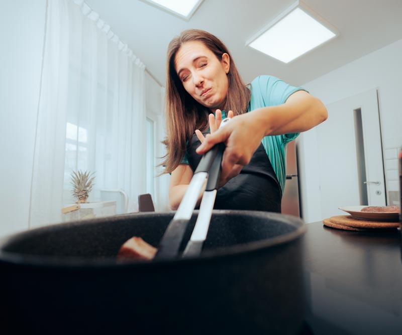 Woman Afraid of Hot Oil Accident Cooking with Her Eyes Closed