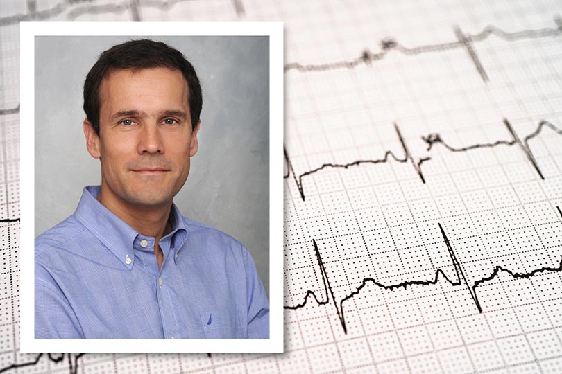 Headshot of Dr Andras Bratincsak with a background of an EKG readout.