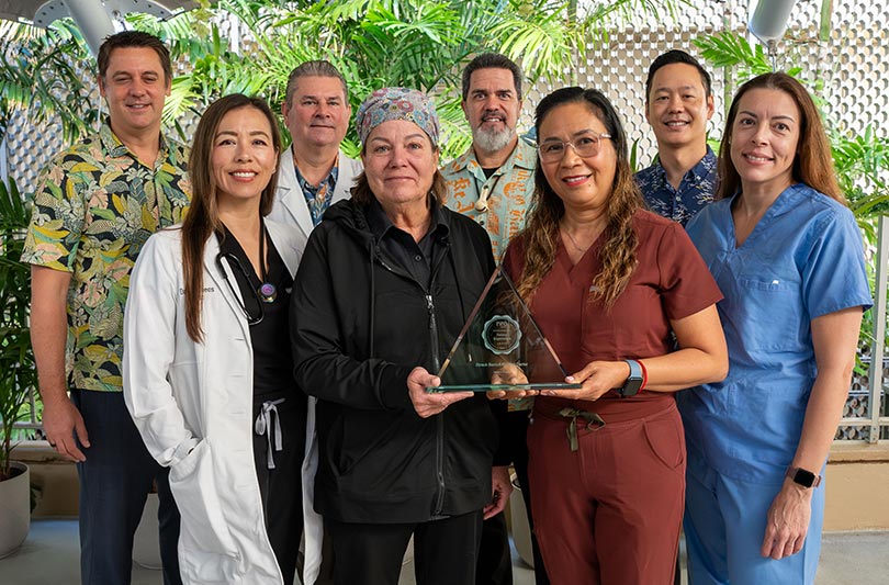 Group shot of health care providers and administrators, holding an award.