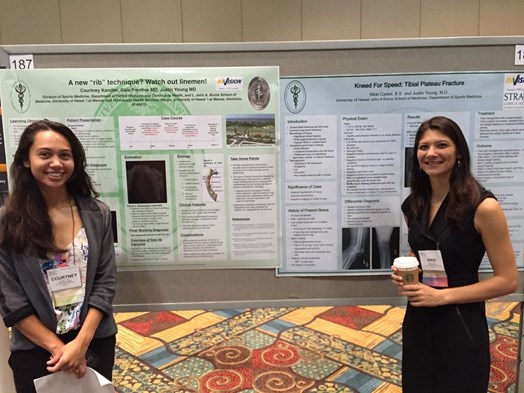 Two females standing next to posters