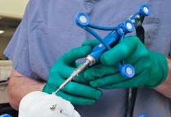 A surgeon holding the NAVIO system