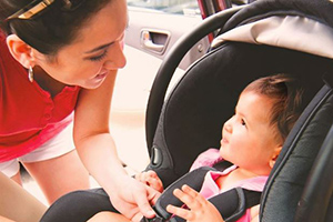 Mother buckles child into a car seat